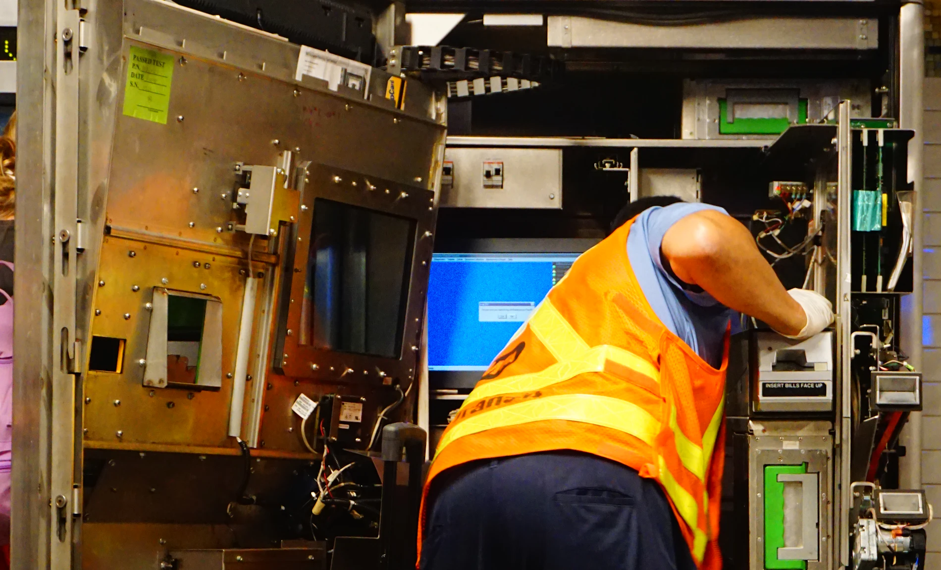 A technician in a safety vest servicing equipment