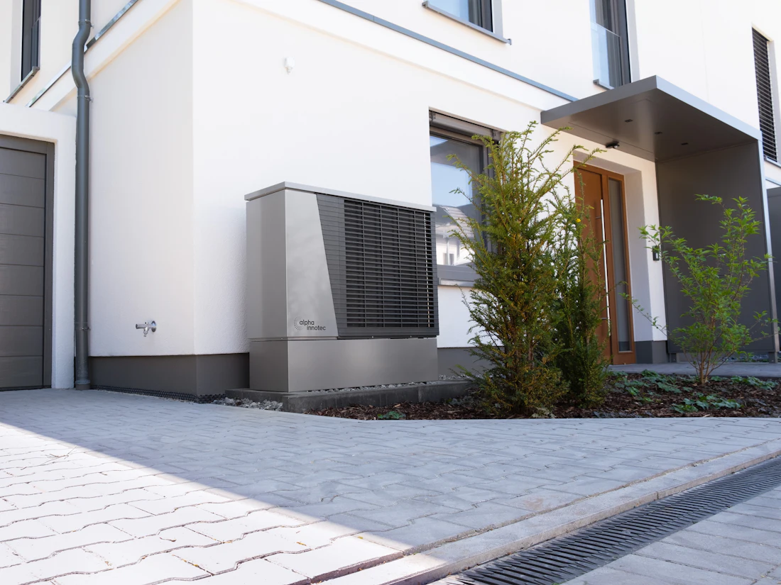 A modern home with a heat pump unit beside the wall